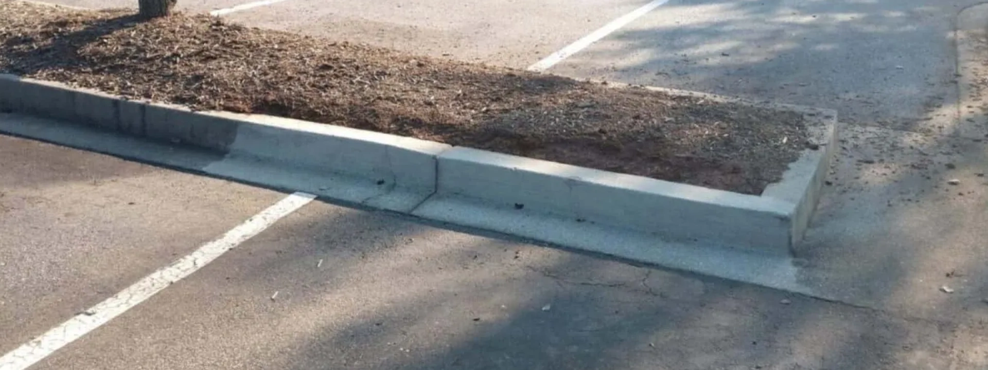 Concrete wheel stop in empty parking stall
