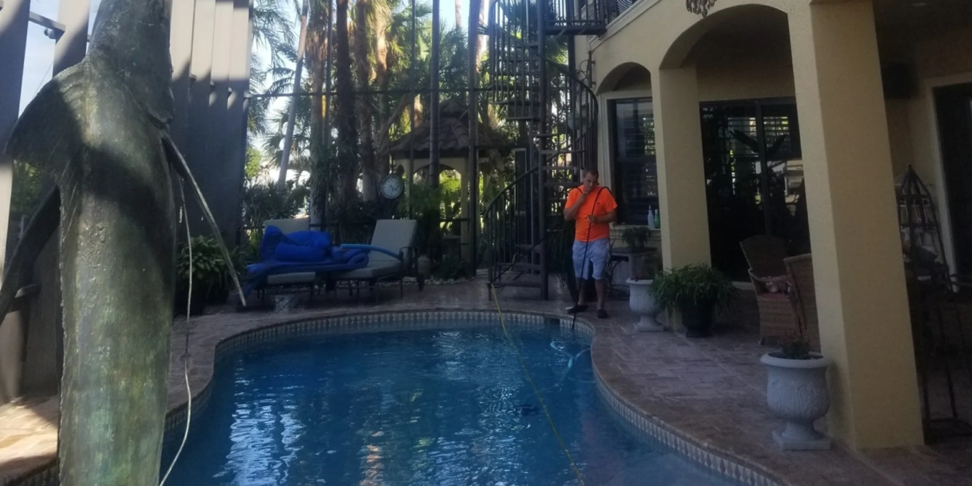 Backyard pool area with person in orange shirt