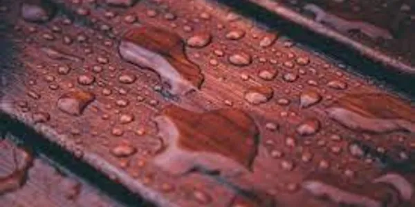 Raindrops on red wooden surface