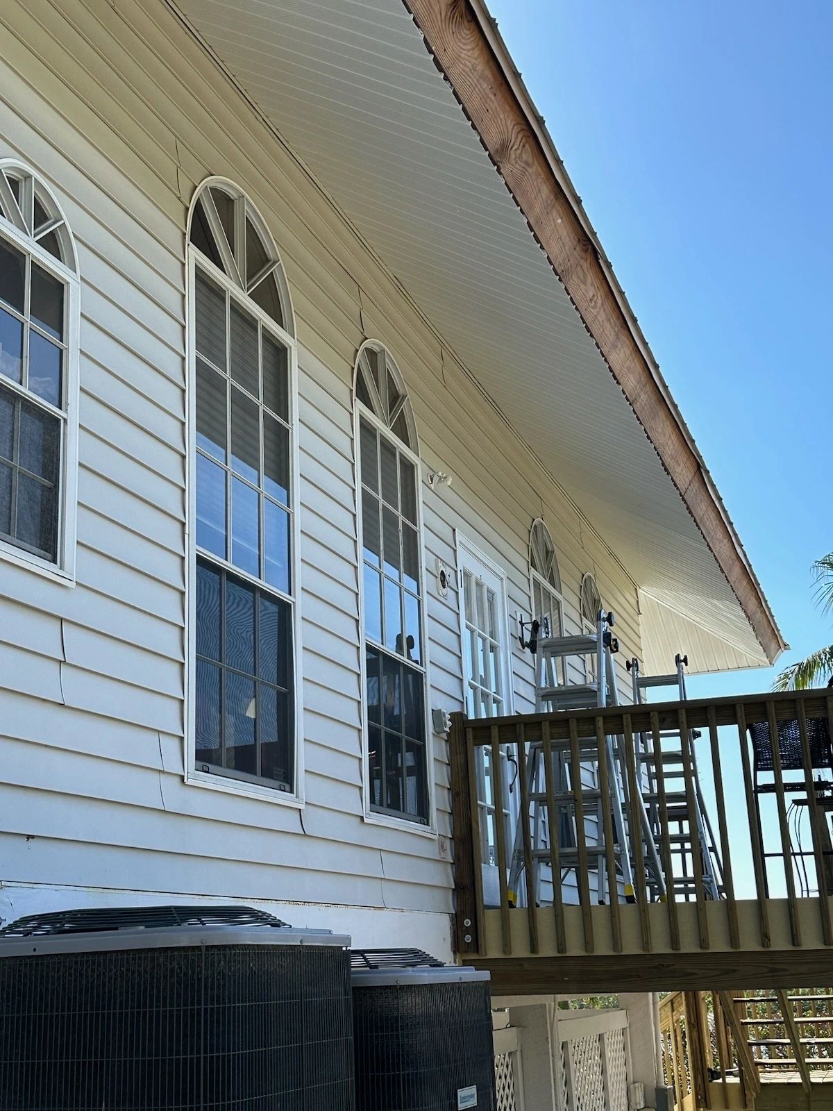 House side with arched windows and deck