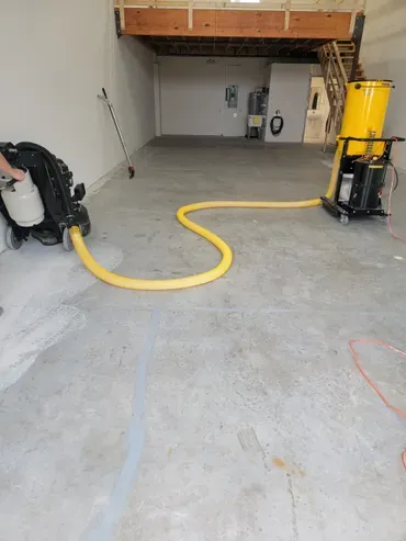 Concrete floor with yellow vacuum hose