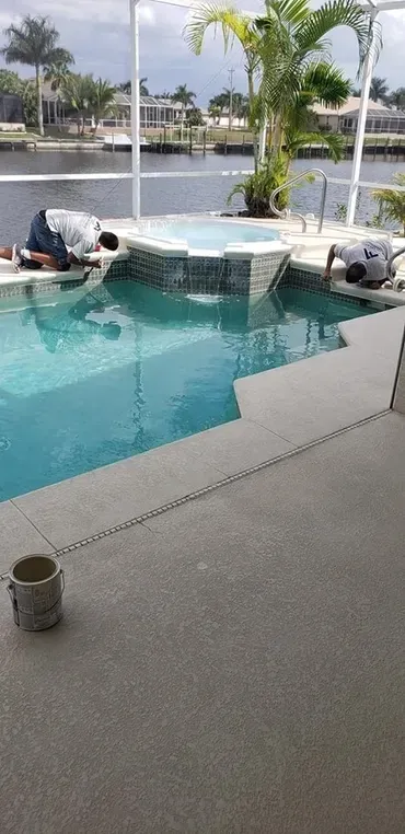 Workers repairing backyard pool spa by canal