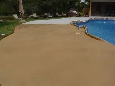 Backyard pool with tan concrete deck