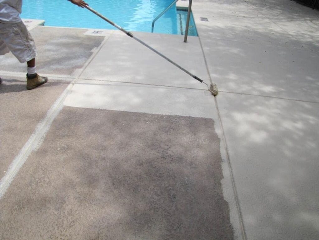 Person applying sealer to pool deck