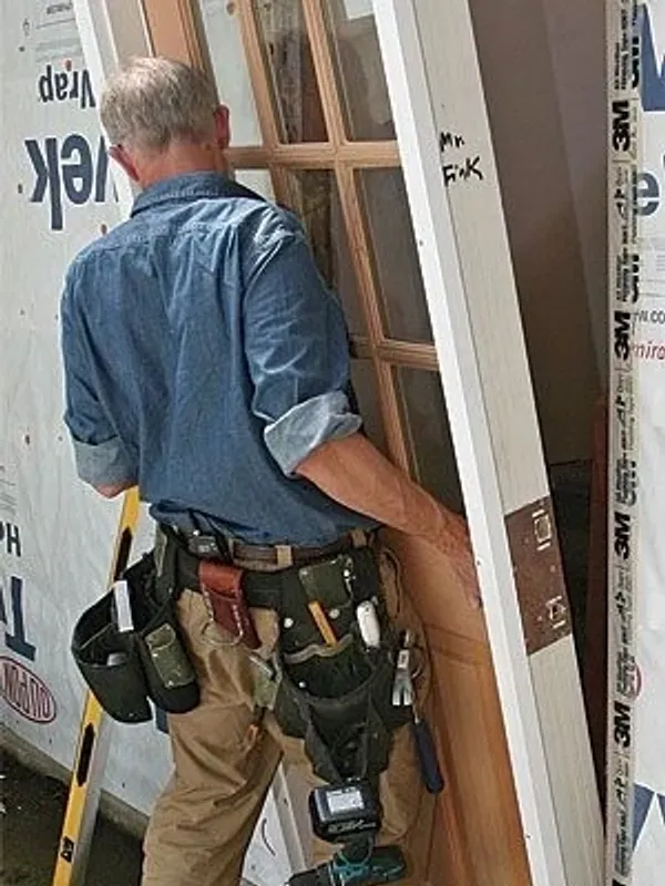 Construction worker installing wooden door
