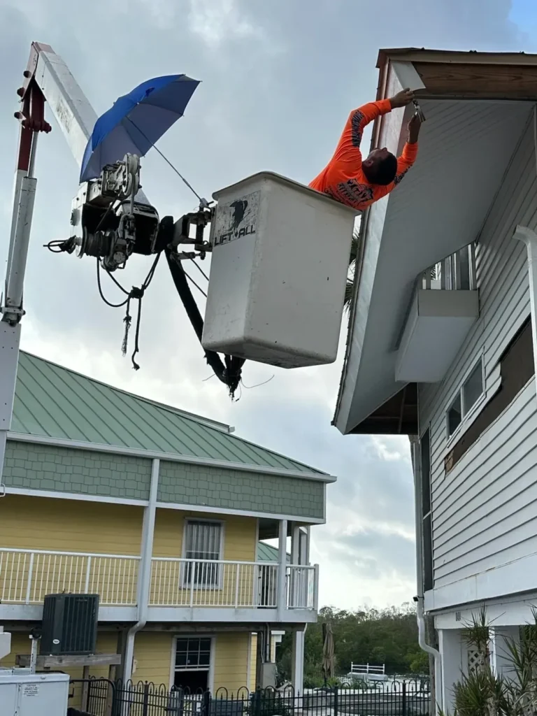 Worker in bucket truck repairing house eaves