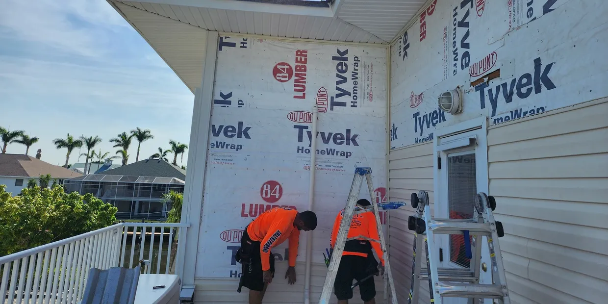 Workers installing Tyvek house wrap on balcony