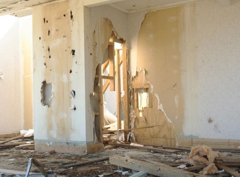 Damaged interior room with torn drywall