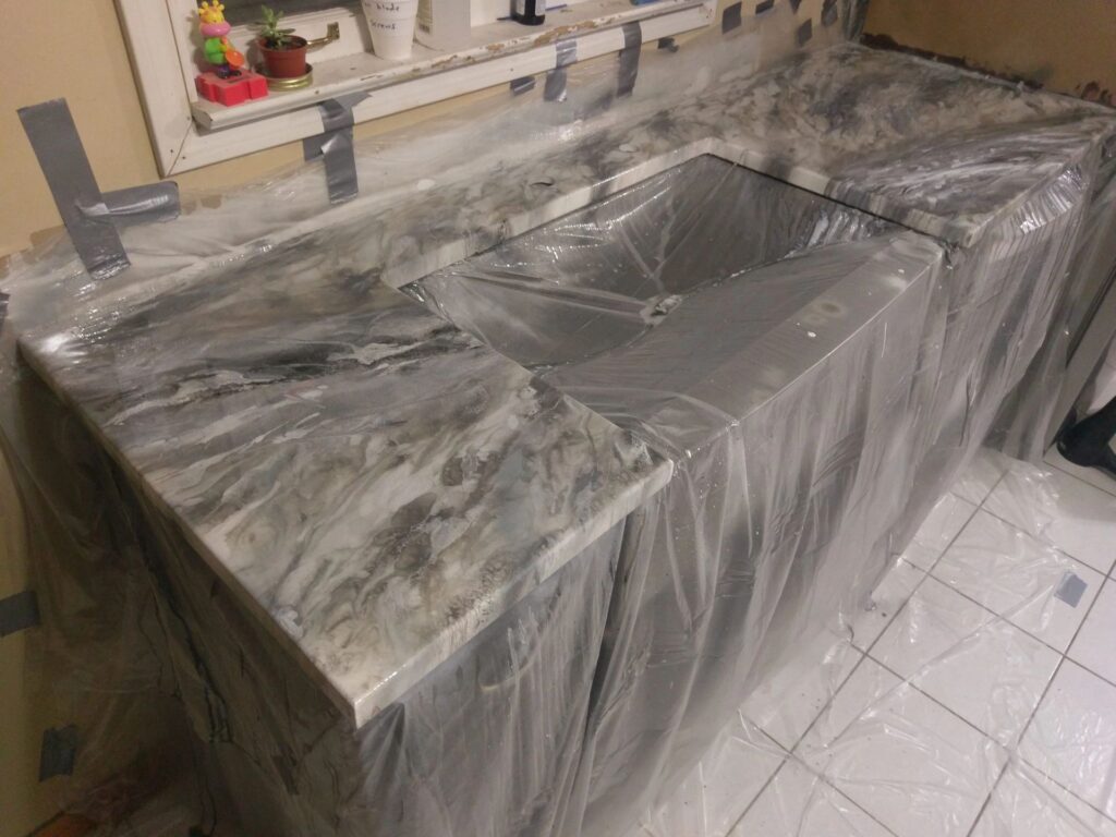 Marble-pattern countertop with sink covered in plastic