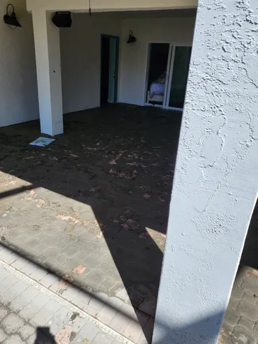 Covered patio with tiled floor and debris