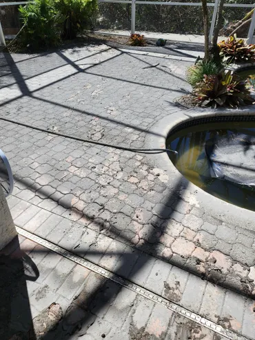 Cracked paver patio around screened pool