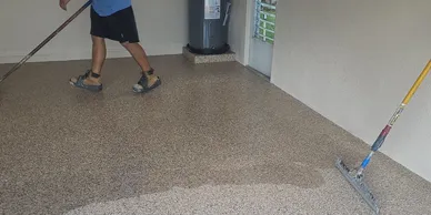 Worker spreading epoxy garage floor coating