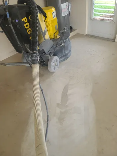 Concrete floor grinder with vacuum hose