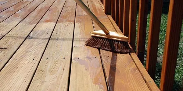 Broom sweeping wet wooden deck boards