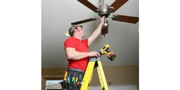 Person on ladder fixing ceiling fan