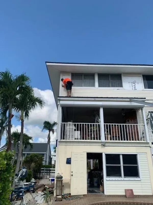 Worker on exterior of multi-story house