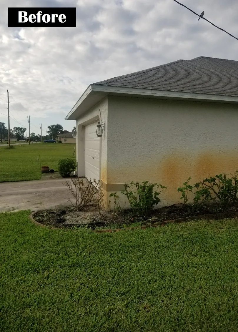 Garage exterior with rust stains and shrubs