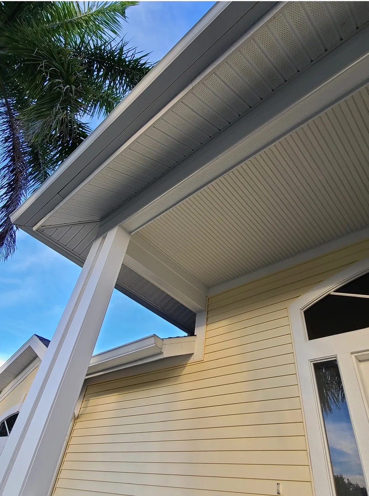 Yellow house exterior with porch and palm