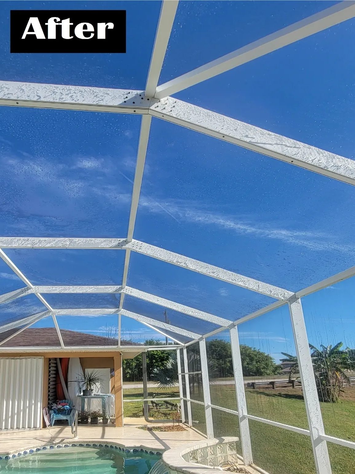 Clean white screened pool enclosure against blue sky