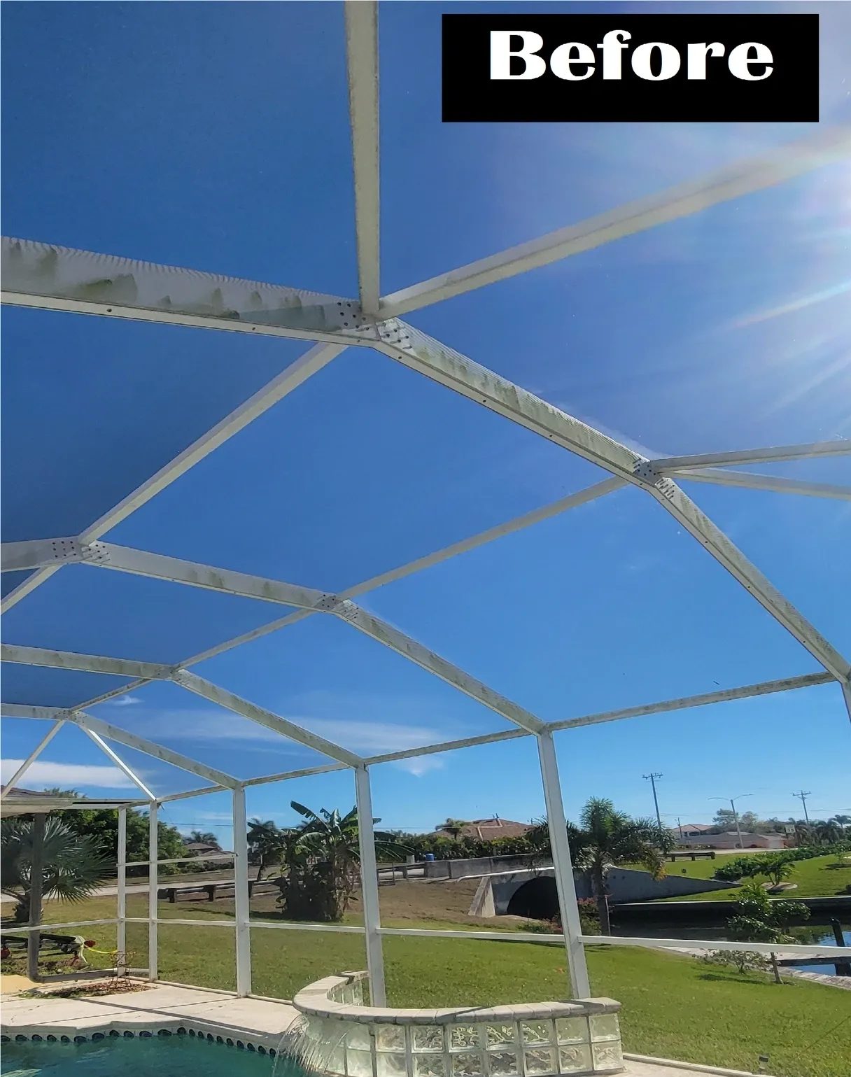 White pool enclosure frame against blue sky