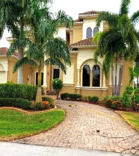 Mediterranean villa with palm trees and driveway