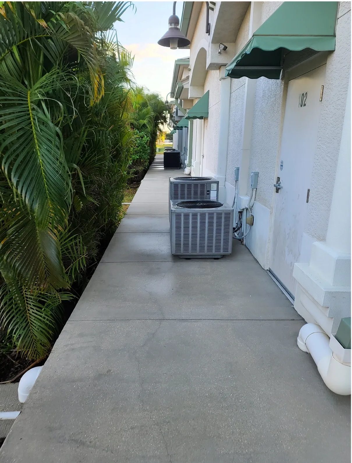 Sidewalk with air conditioning units and palms