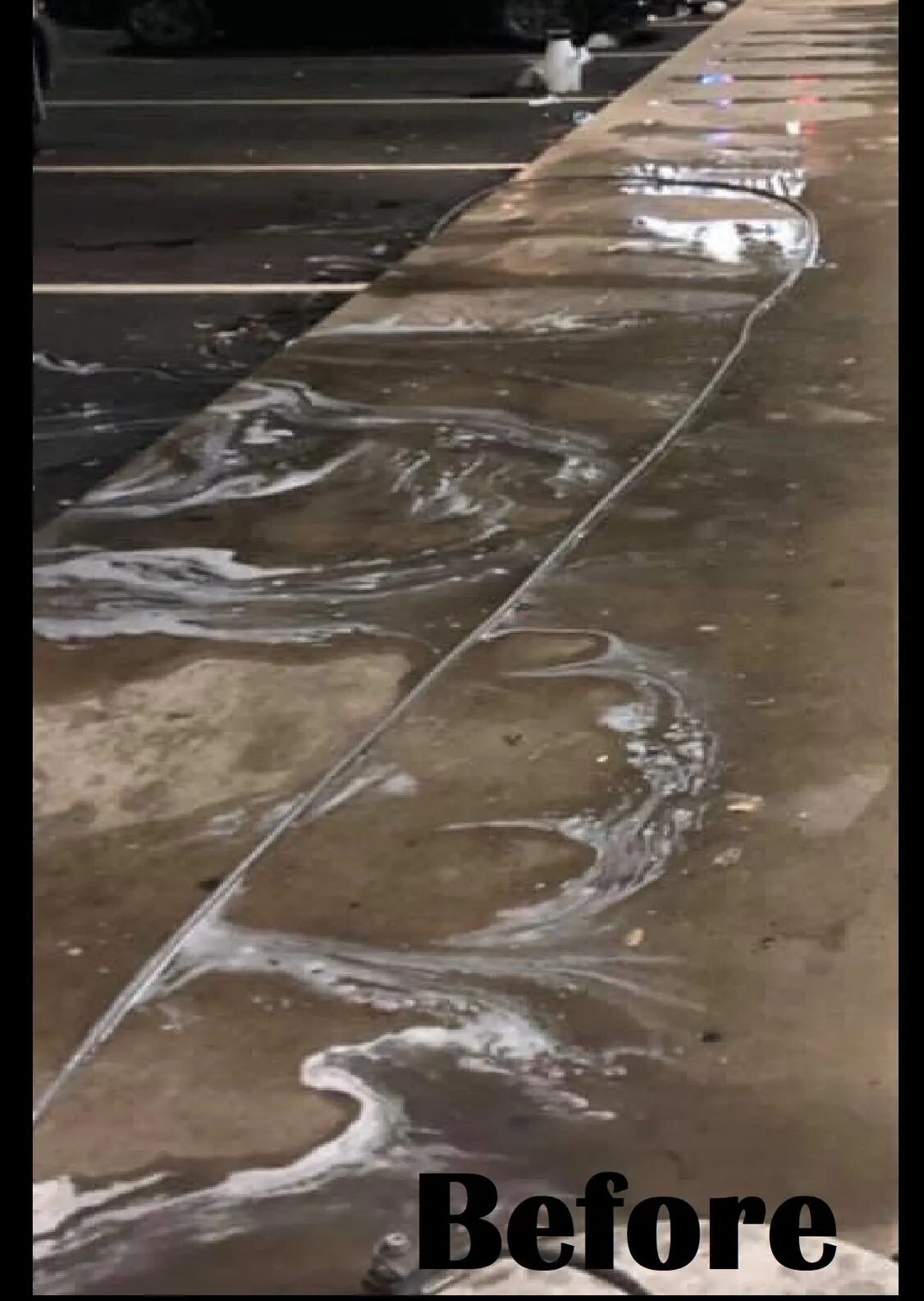 Soapy water on concrete curb before cleaning