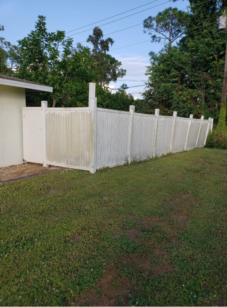 White privacy fence along grassy backyard