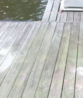 Weathered wooden dock planks beside calm water