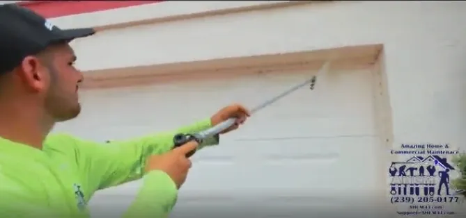 Worker sealing garage door frame with caulking gun