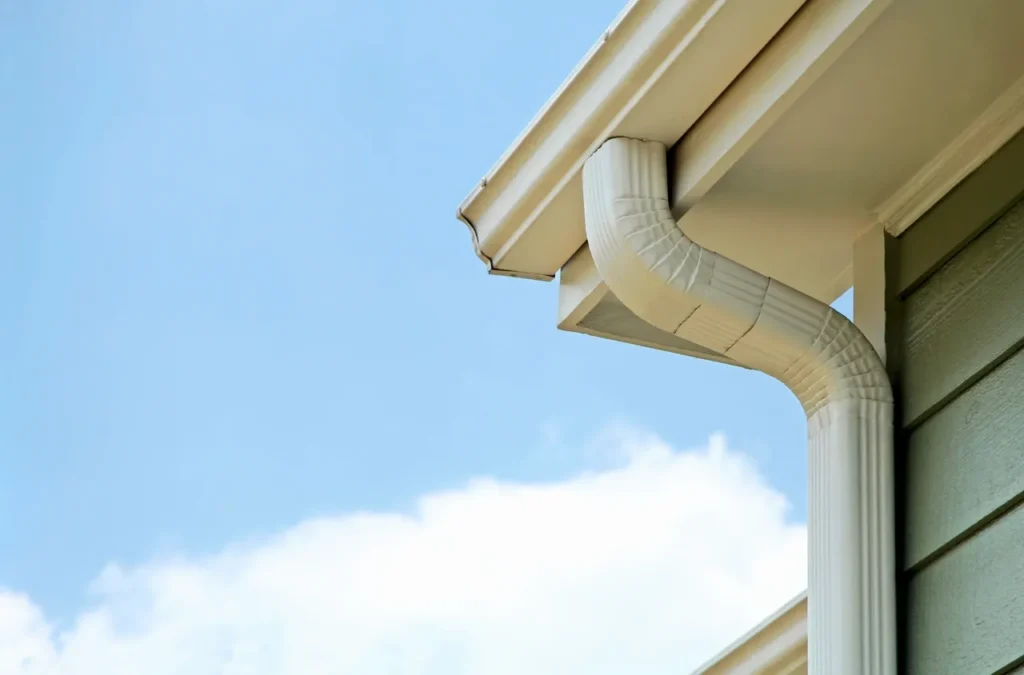 White house downspout against clear blue sky