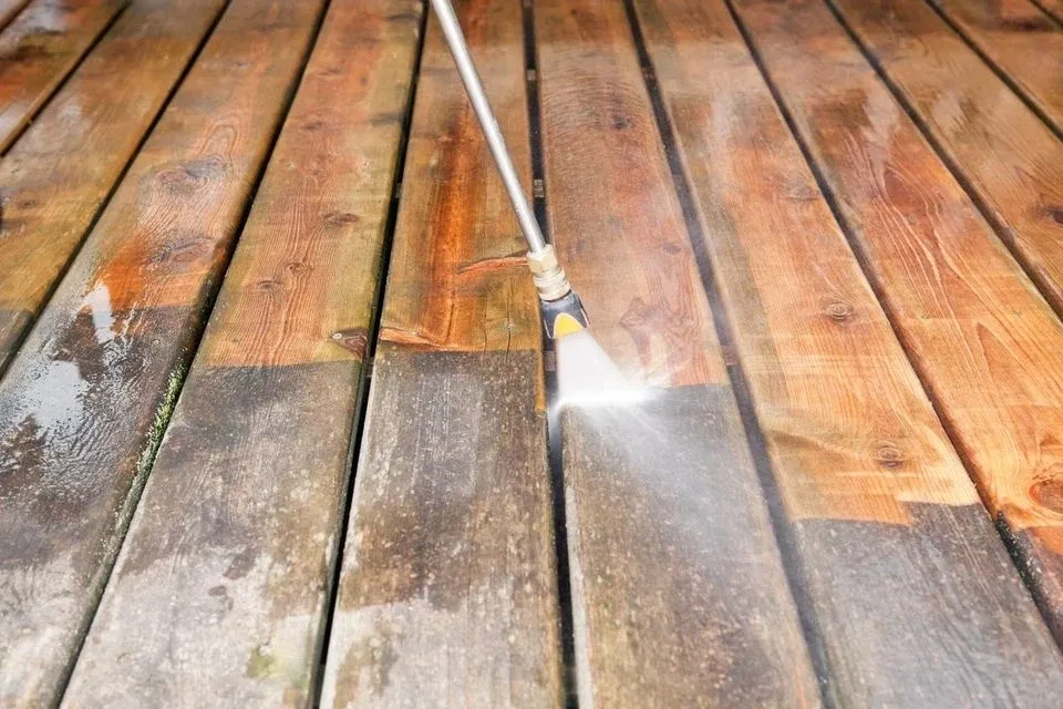 Pressure washing wooden deck removing grime