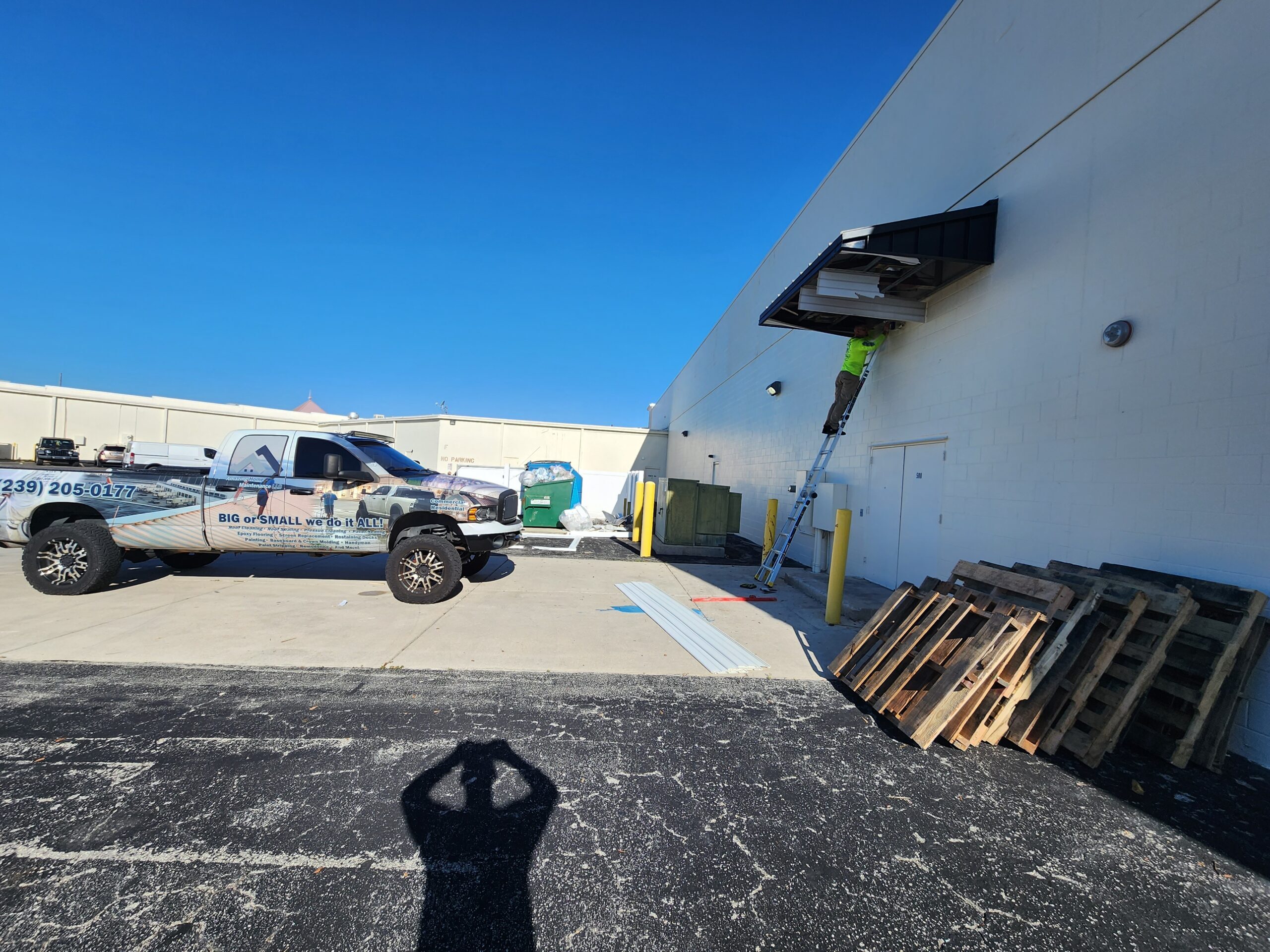 Worker on ladder at warehouse loading dock