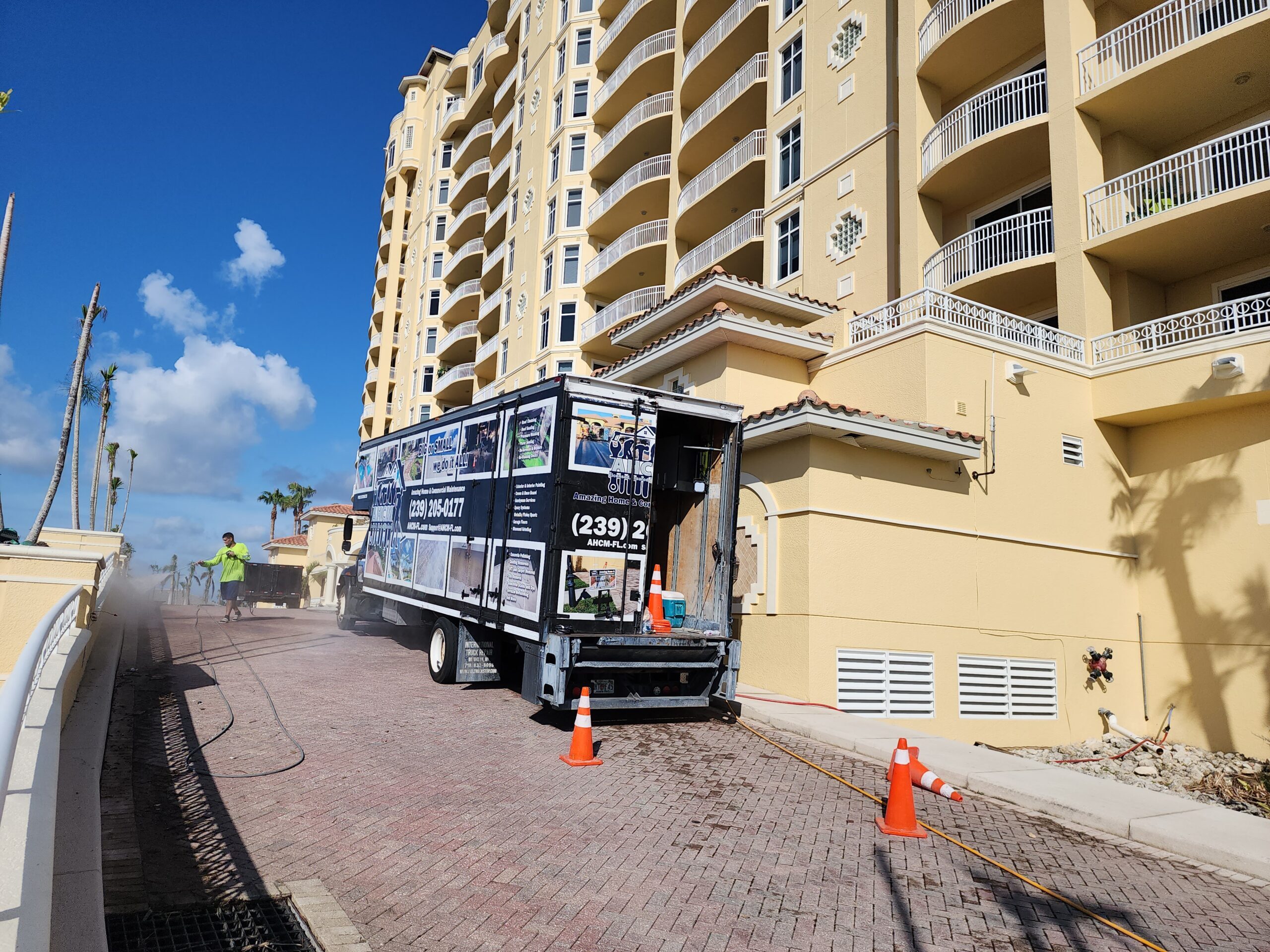 Pressure-wash truck at yellow beachfront condominium