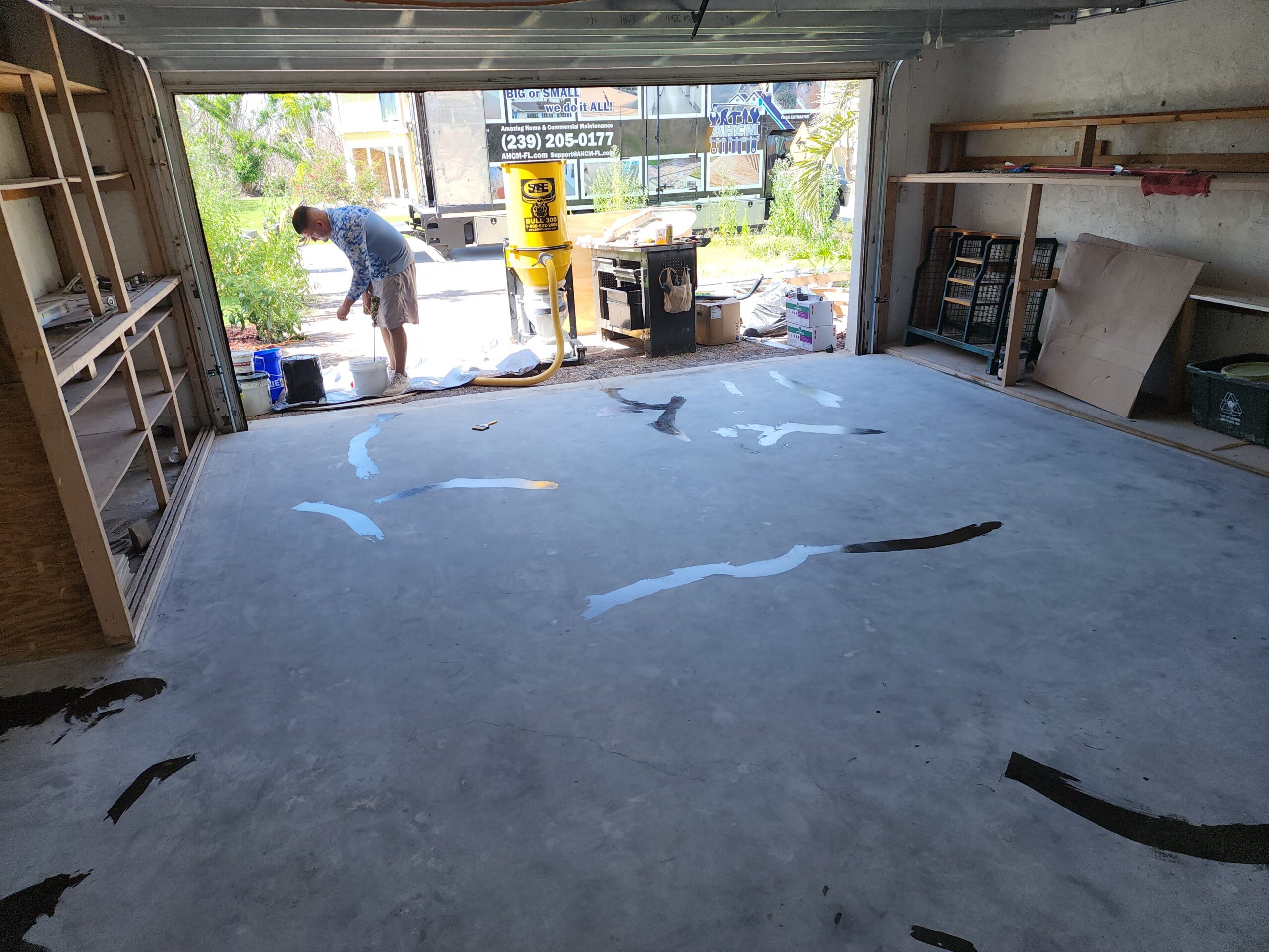 Worker renovating garage floor with tools