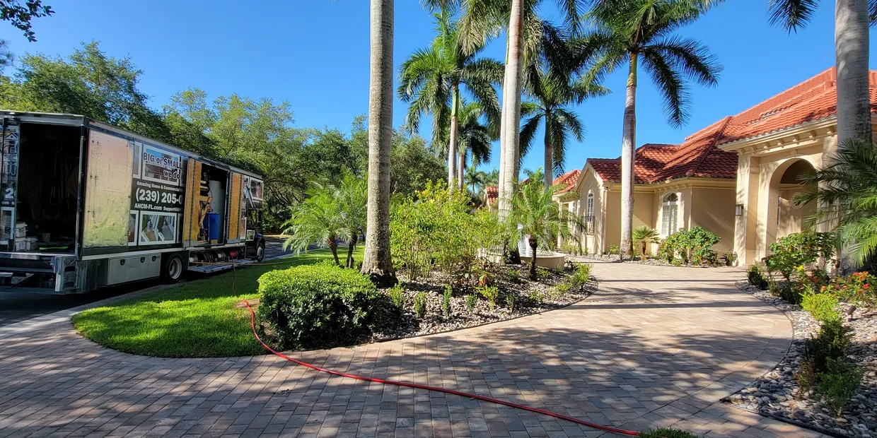 Moving truck at tropical mansion driveway