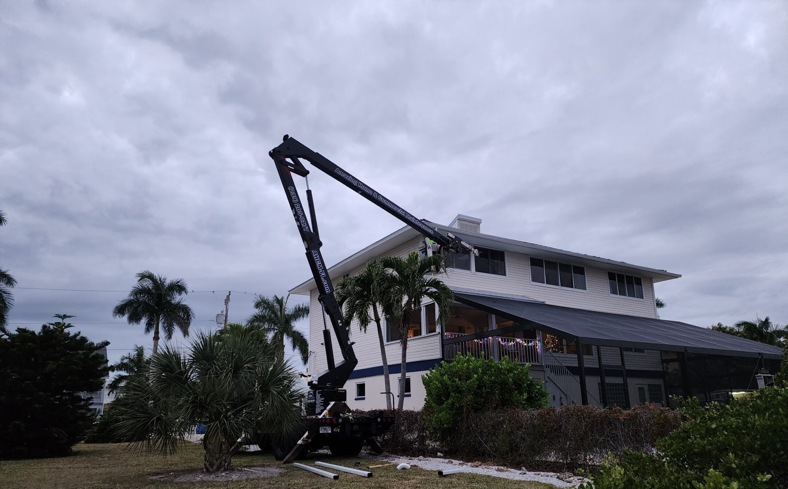 Boom lift beside two-story house