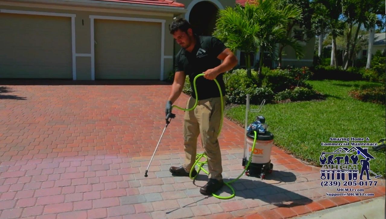 Person pressure-washing paver driveway