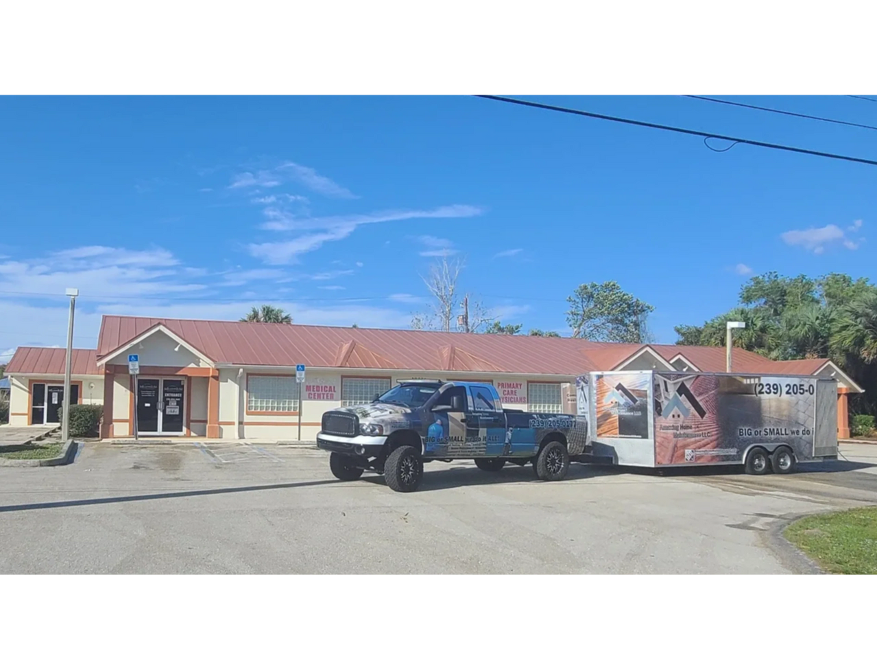 Truck and trailer parked outside single-story building