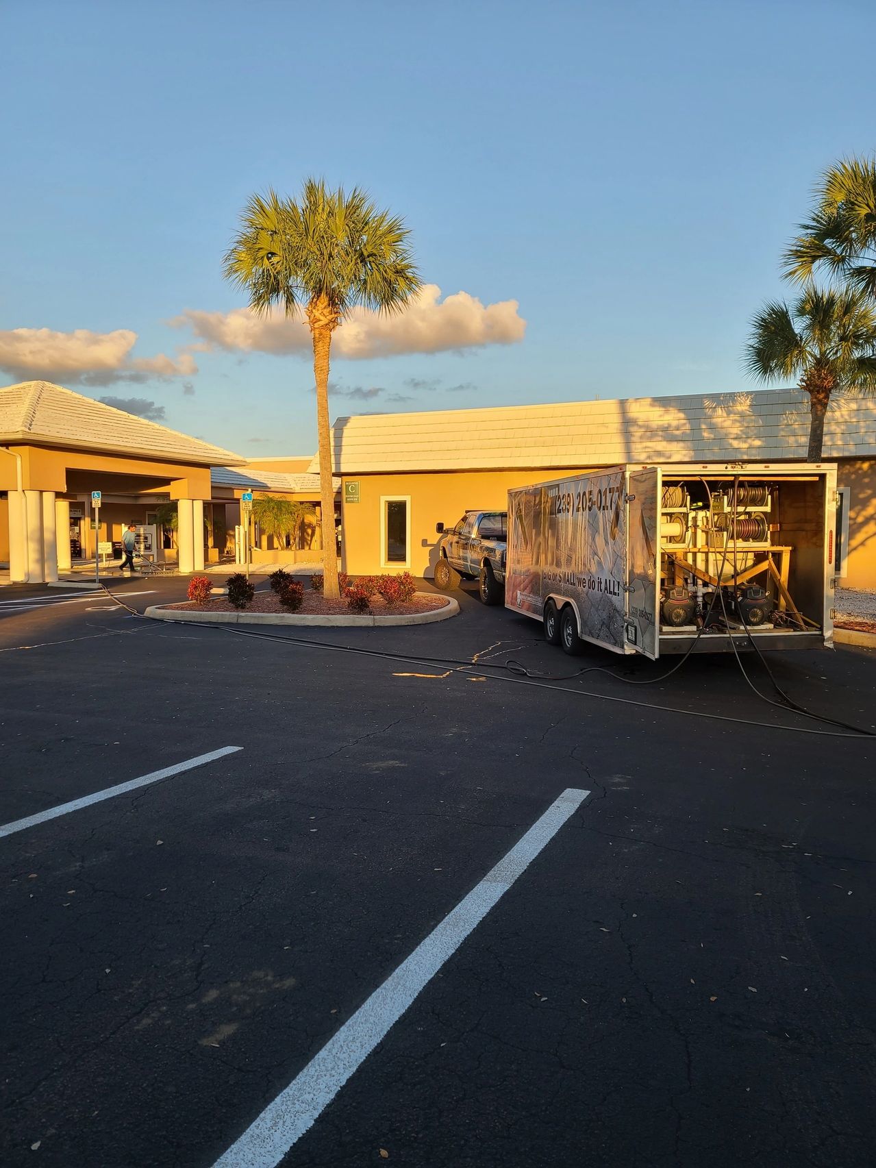 Sunlit hotel parking lot with service trailer