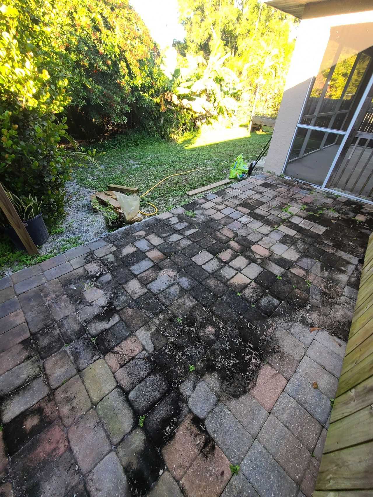 Mossy paver patio beside screened porch