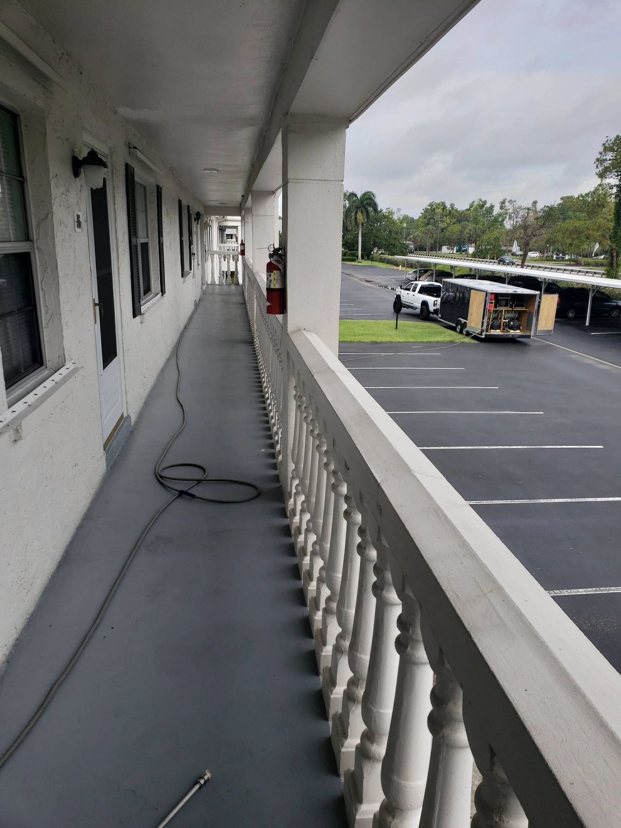 Exterior motel walkway overlooking parking lot