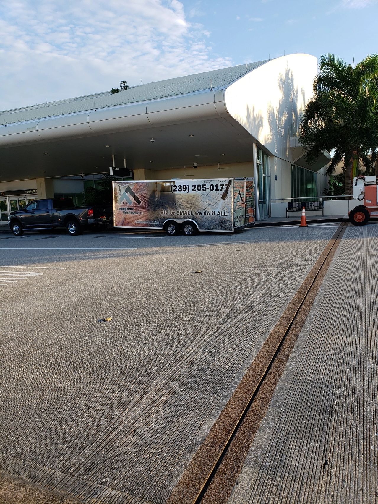 Airport curbside with parked advertising trailer