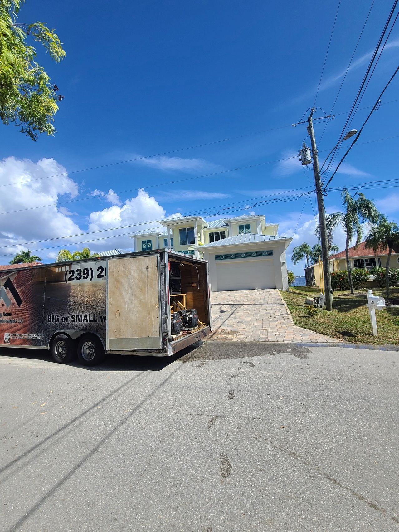Open moving trailer parked outside coastal house
