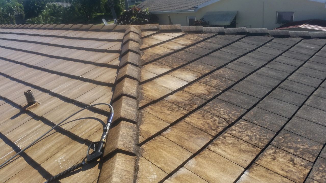 Half-cleaned tiled roof showing cleaning progress