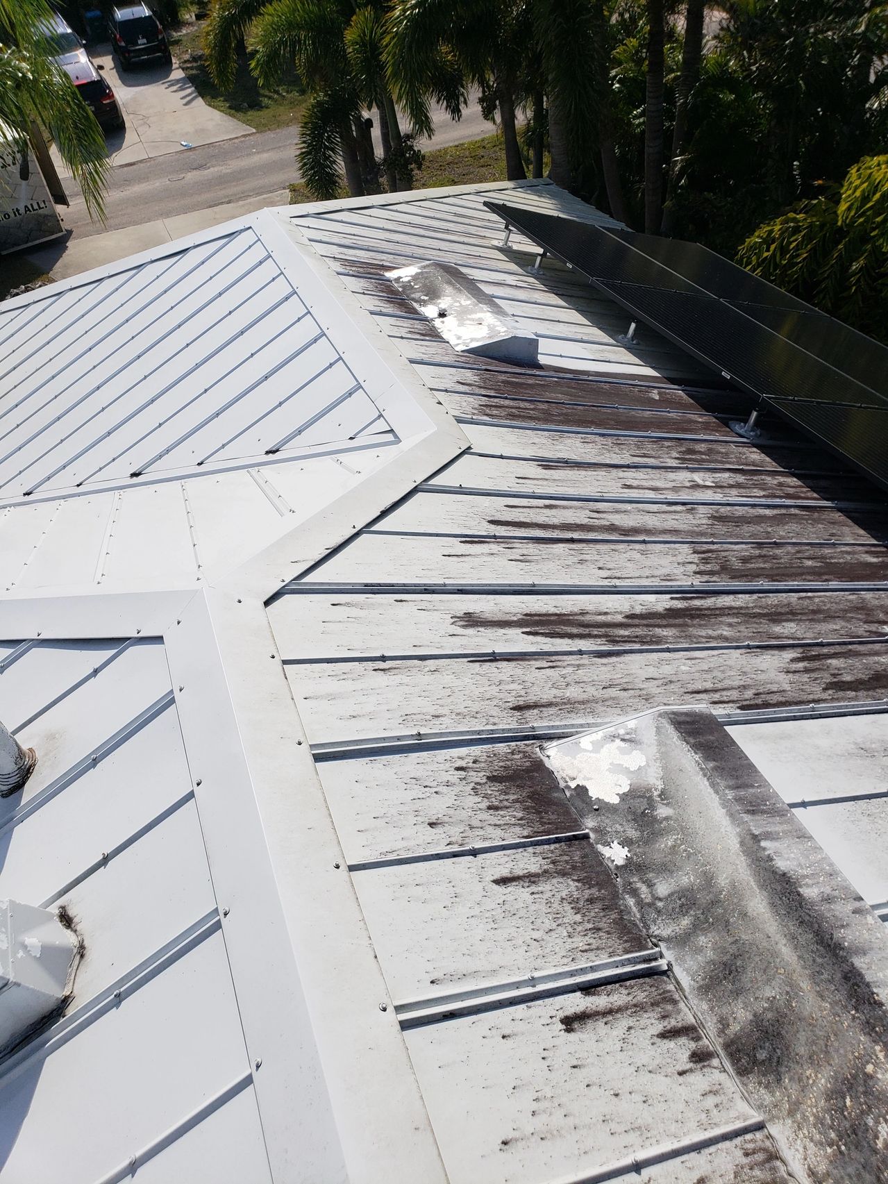 Corroded white metal roof and solar panels