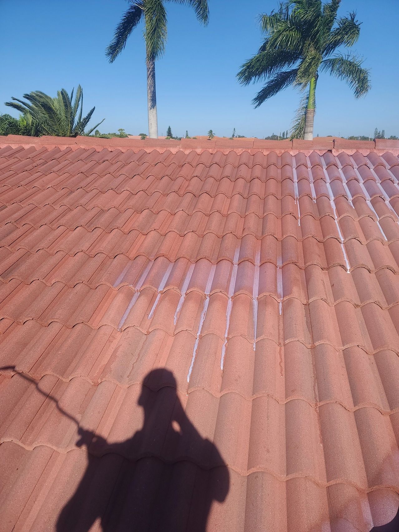 Person's shadow on terracotta tiled roof