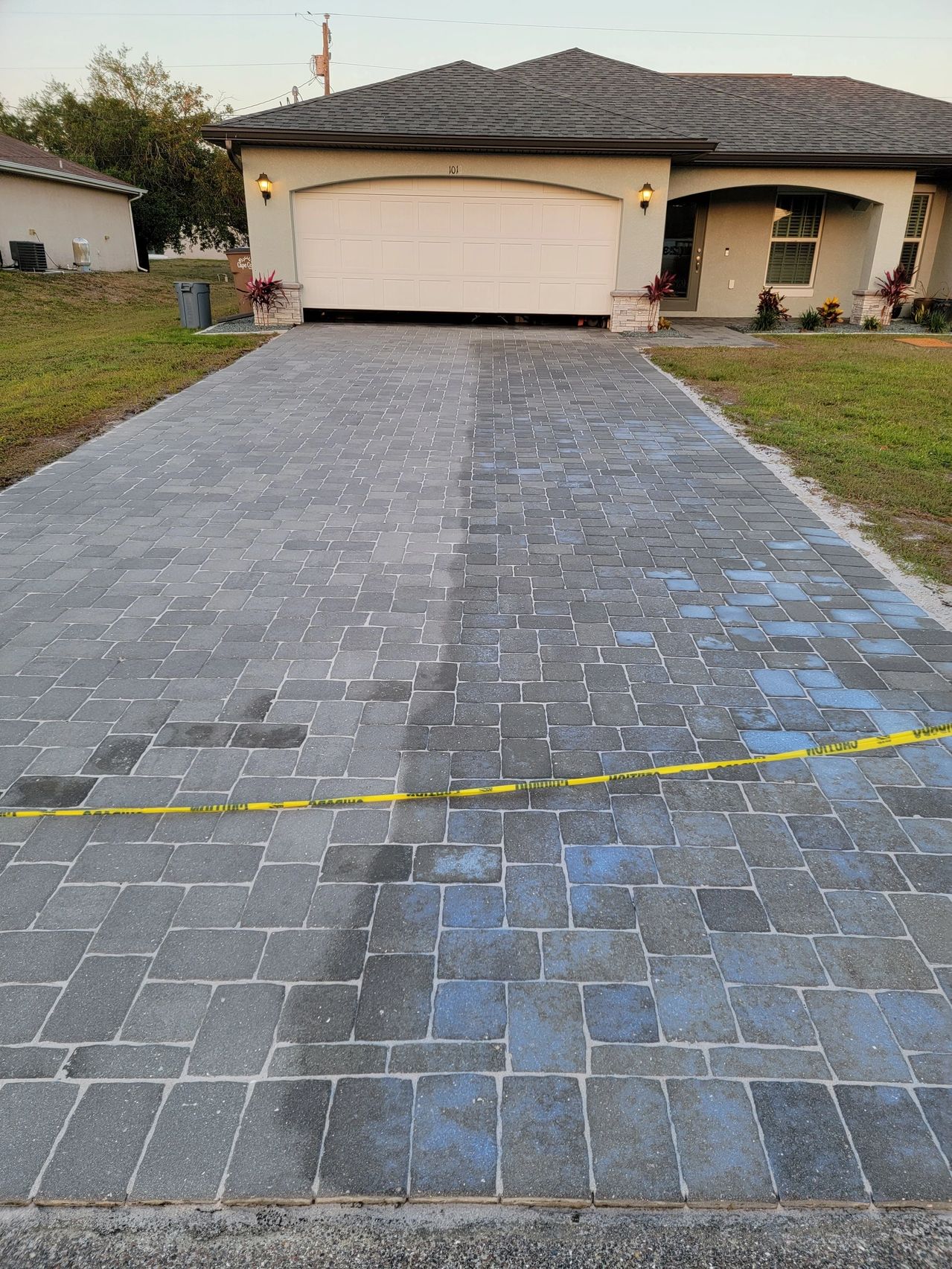 Paver driveway with caution tape leading to garage