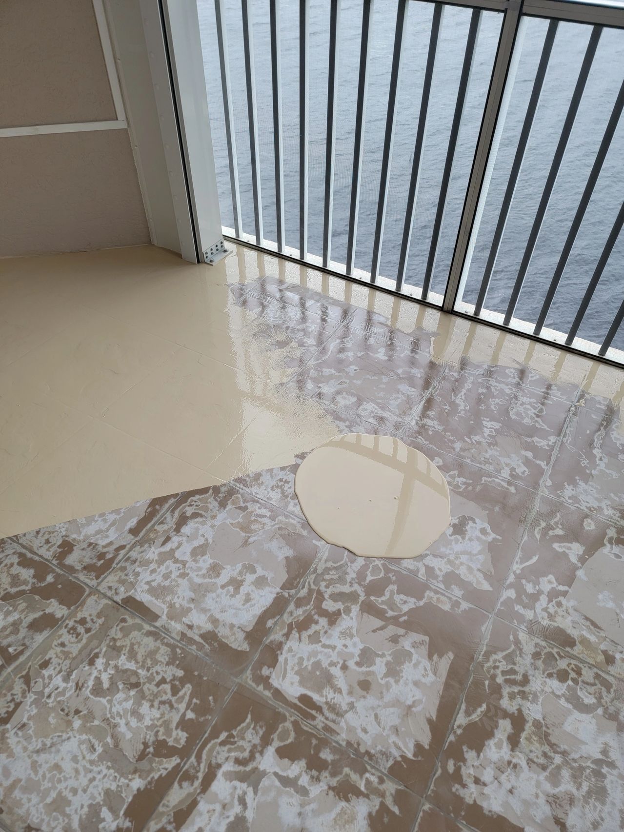 Wet balcony floor with puddle and railing