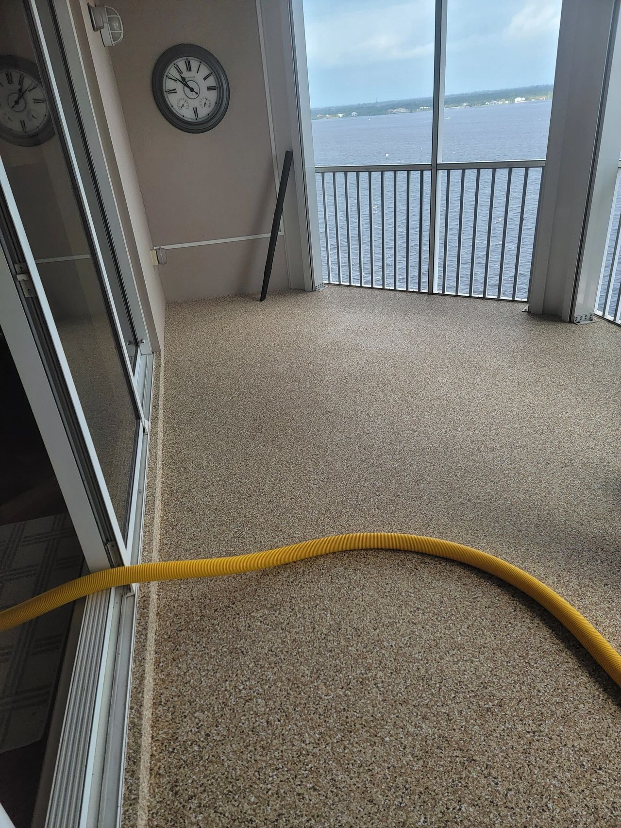 Apartment balcony with water view and hose